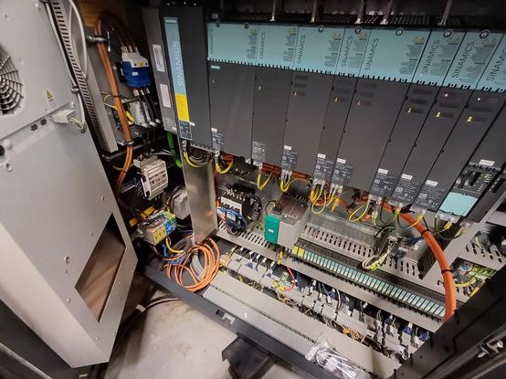 detailed view of Siemens SINAMICS drive controllers mounted in an electrical cabinet. Cables, along with control wiring, are neatly arranged to supply and control different industrial equipment.