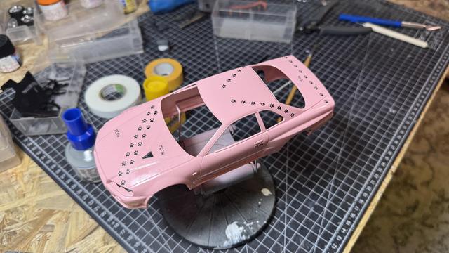 Body of a Nissan Skyline GT-R (34) by Tamiya in pink on top of a workbench.