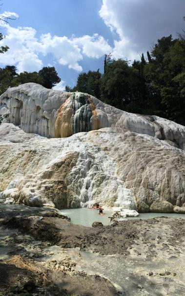 A rocky landscape completely covered in chalk sediment and a small pool at the bottom.