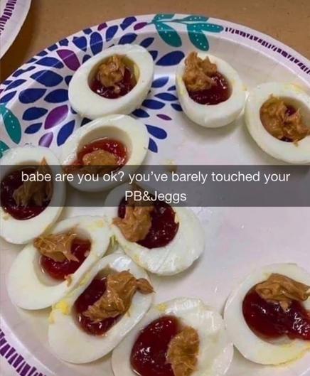 A paper plate of halved hard-boiled eggs filled with dollops of jelly and peanut butter, labeled “PB&Jeggs” with the caption “babe are you ok? you’ve barely touched your PB&Jeggs.” The eggs look deeply unappetizing, like someone confused deviled eggs with a school lunch sandwich.
