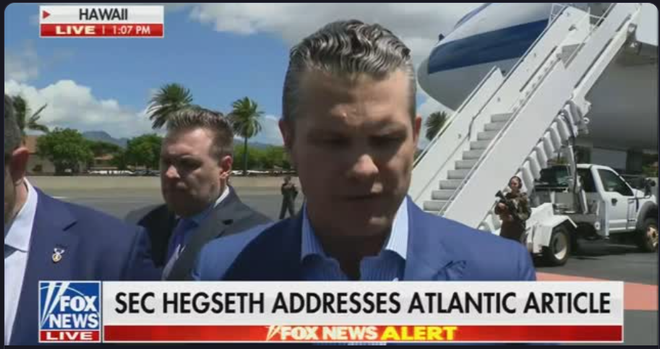 Screen grab from Fox News showing Secretary of Defense and email idiot Hegseth emerging from an airplane. Banner "SEC HEGSETH ADDRESSES ATLANTIC ARTICLE."
