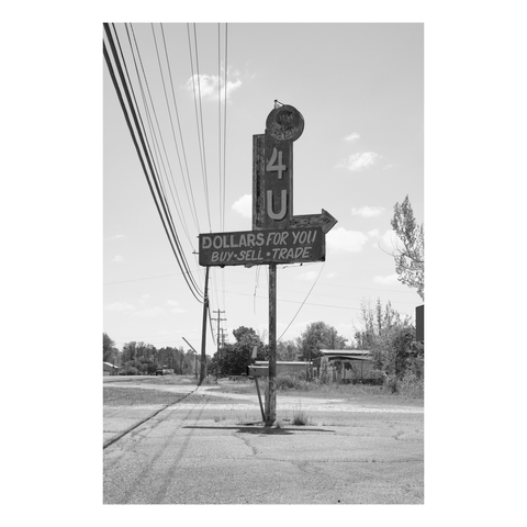old roadside sign in broken parking lot