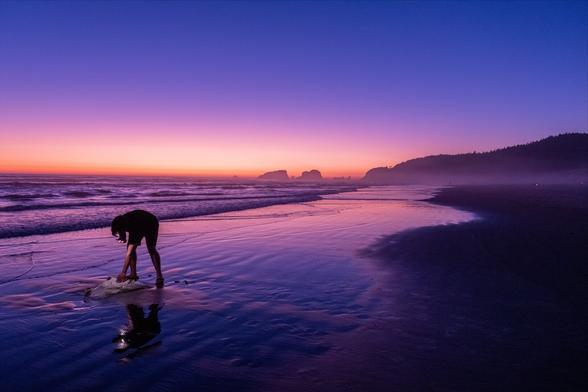 A boy discovers a beached sting ray in the late evening colors of north Cannon Beach