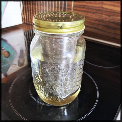 A cold brew jar with almost clear water sitting on a stove top