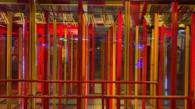 Rote und gelbe Stangen, dazwischen (unsichtbar auf dem Foto) Glaswände eines Labyrinthes.