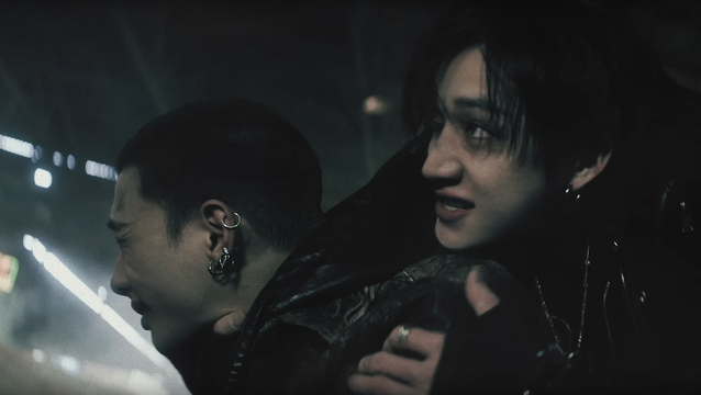 Bang Chan is behind Hyunjin, holding his shoulder with one hand, and with the other hand around the front of Hyunjin's neck