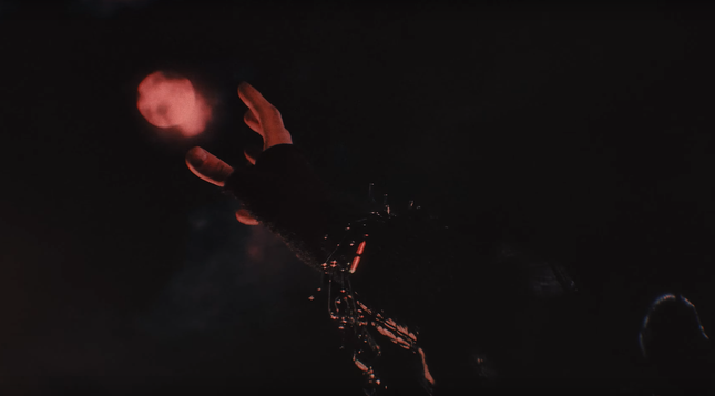 Bang Chan's hand reaching out to a red full moon
