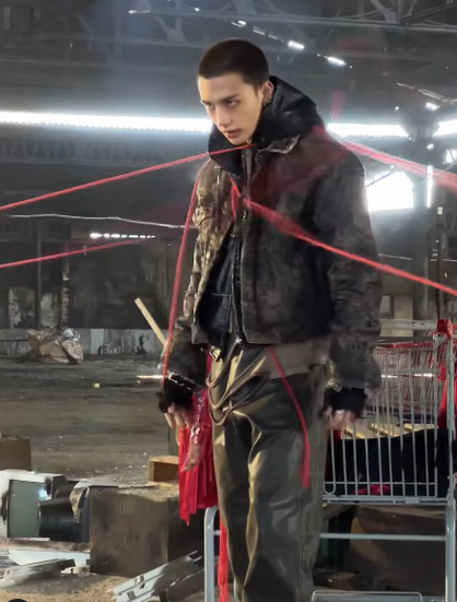 Hyunjin in the middle of having the red ropes pulled off him