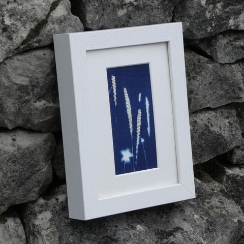 Same artwork leaning against a stone wall from an angle to show texture
