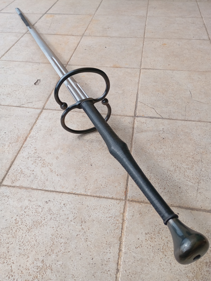 A schlachtschwert - a two-handed late medieval battle sword. The handle of the sword is wrapped in black leather and the steel of the pommel and rings are blackened.
