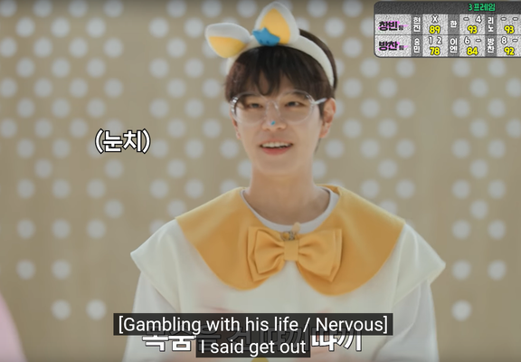 Seungmin, dressed as a teenieping, smiling at Changbin. Caption: [Gambling with his life / Nervous] I said get out