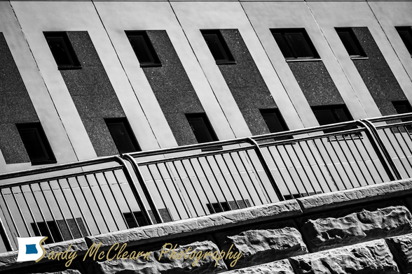 Railing on an odd angle in front of a concrete building.
