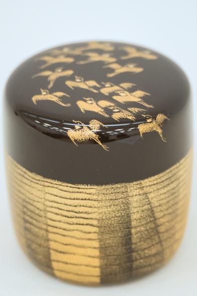 Black and gold lacquer container with bird design on top