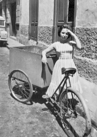 Foto en blanco y negro de los años cincuenta con una mujer en una bici con cjaón para repartir el pan en  Santa Cruz de Tenerife