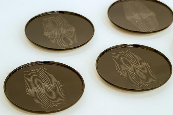 At a high angle, lacquer plates with a delicate gold and black motif, but...