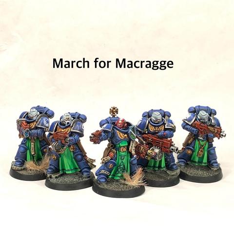 A squad of blue-armored space marines holding red rifles and in action poses. They stand on tan ground. Their helmets are white except for the squad leader with a red helm with a white stripe. They have green tabards and gold relics hand from their belts.
