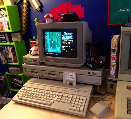 Photo of an Atari 520STm computer setup with SC1224 color monitor, and Apple IIe seen just to the right of it on the same desk