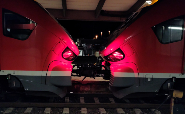 the picture shows two red locomotives facing each other in a combined train. they appear to look a bit aggressive like two sharks attempting to attack eachother