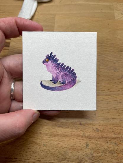 Tiny watercolour painting of a purple and pink dragon