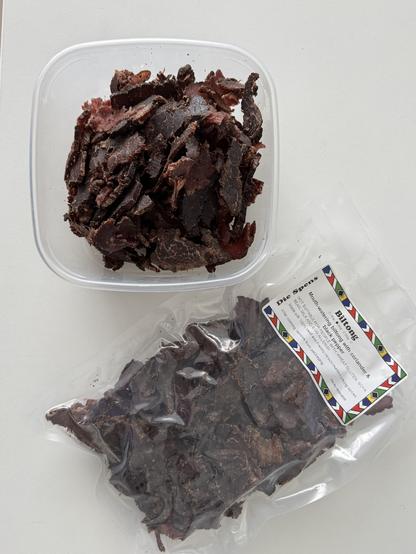 Een bakje en een gevacumeerd zakje met verse biltong, met de gebruikelijke biltong-kruiden. Afkomstig van Die Spens, een winkel met veel Zuid-Afrikaanse producten.