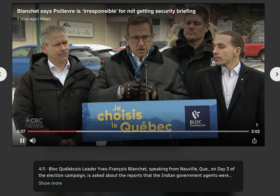 Yves-Francois Blanchet speaks behind a podium that says “je choices le Quebec” surrounded by 3 men in black jackets. It’s snowing.