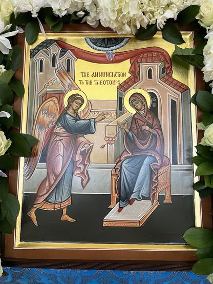 A Byzantine-style icon of the Annunciation. On the left, the archangel Gabriel gestures toward Mary, on the right, who is seated and holding a spindle of red thread.