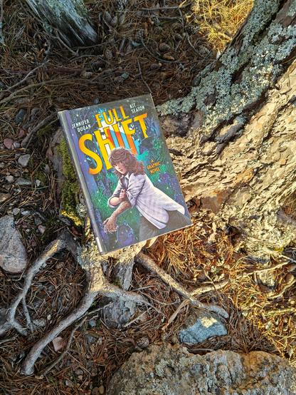Kuvassa Full Shift -kirjan kansi kuvattuna puun juurakossa.
