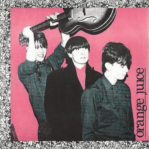 The coverm of Falling & Laughing, debut single by Orange Juice. Three young men in black and white on a pink background with a floral border on three sides. One of them, Edwyn Collins, is holding a guitar above his head.