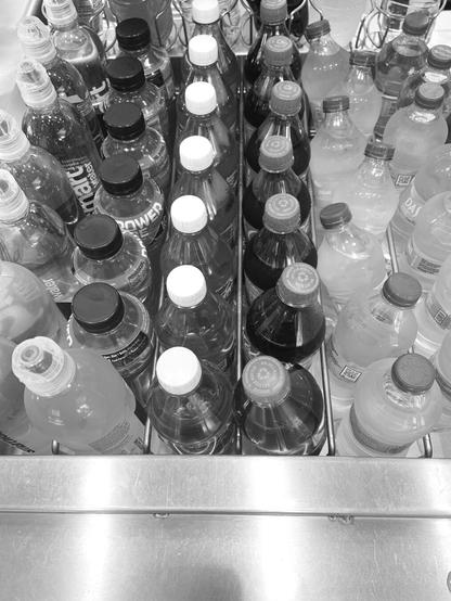 Top view of an open fridge with many bottles in rows
