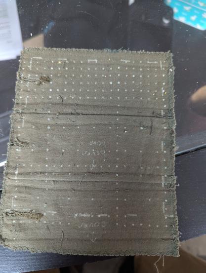 A piece of fabric with white dots on it, to help with making a grid.