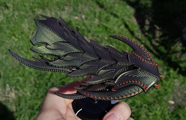 miniature alien spaceship, organic, green and purple, kinda like a trilobite, with orange dots