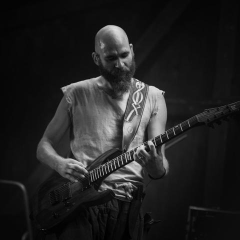 Ilann qui joue de la guitare en noir et blanc.