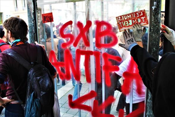 Tag "Strasbourg antifasciste" avec trois flèches vers le bas (symbole antifasciste)