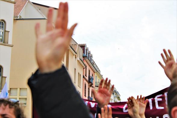 Des manifestant•es lèvent les mains en l'air pour scander "Siamo Tutti Antifascisti"