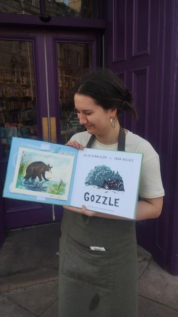 bookseller Sarah holding open the picture book Gozzle, to show the limited edition print