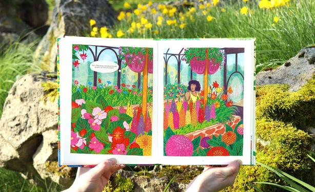 Now we move on to pages 70 and 71, a little further in the story, featuring a full double-page illustration. Églantine is inside an exhibition greenhouse, marveling at the various flowers around her. There are lupins, pompom dahlias, poppies, and petunias. Through the greenhouse windows, sunflowers can be seen.