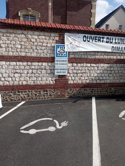 Une station de recharge pour voiture électrique. Une personne a graffé " fuck musk" sur le panneau de recharge