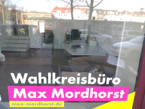 Blick durch ein Schaufenster mit der Aufschrift "Wahlkreisbüro Max Mordhorst". Innen weitgehend leer geräumt, im Vordergrund Umzugskartons