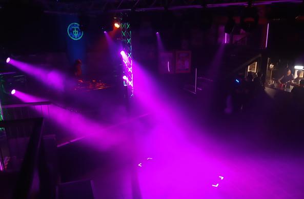 A photography showing the dancefloor of the Dunkelfelltanz before the dance started, illuminated in purple light.