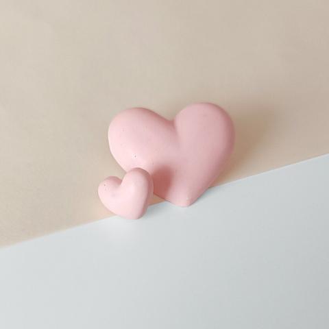 Deze hartjes oorbellen zijn een echt statement. Deze asymmetrische set bestaat uit 1 oorbel van ongeveer 15 mm breed en 1 oorbel van 35 mm breed. Ze zijn van pastel roze Jesmonite (milieuvriendelijke kunsthars) en zijn afgewerkt met een zilveren steker.