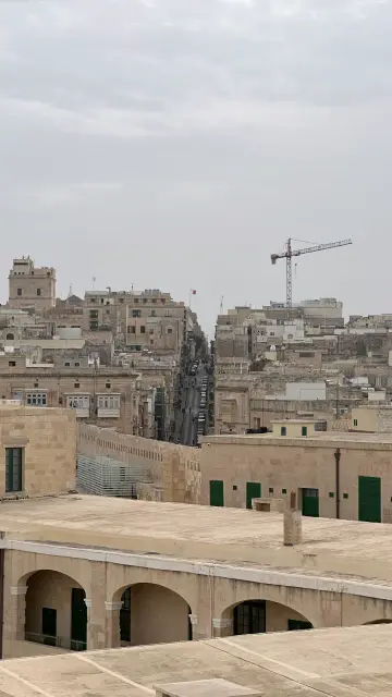 Blick vom Fort St Elmo auf die Altstadt. Viele sandstein-/lehmfarbige Gebäude mit drei bis vier Stockwerken sind sichtbar.