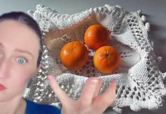 Woman's surprised face to left, porcelain bowl from knitting holding oranges to right