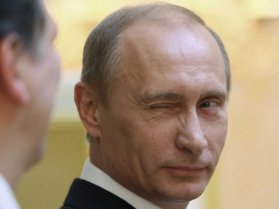 @jemmesedi The image features a close-up of Vladimir Putin. He is wearing a dark suit with a white shirt. He is winking with his right eye, giving a playful expression. His facial features include a prominent nose and a slight smile. The background is blurred, with a warm, yellowish tone, suggesting an indoor setting. Another person is partially visible on the left side of the image, facing Putin. The focus is on Putin's face, capturing his expression and attire.

Provided by @altbot, edited by@jemmesedi