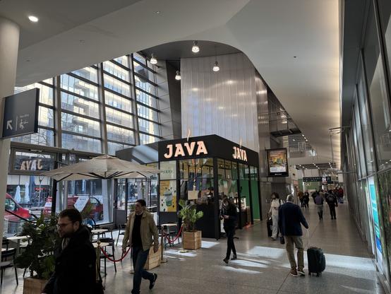 Station hall with a small cafe named JAVA (all caps).