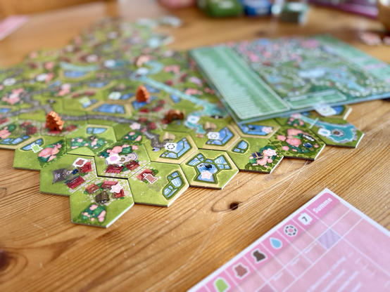 Das Brettspiel Dorfromantik - Sakura auf einem Tisch ausgebreitet.