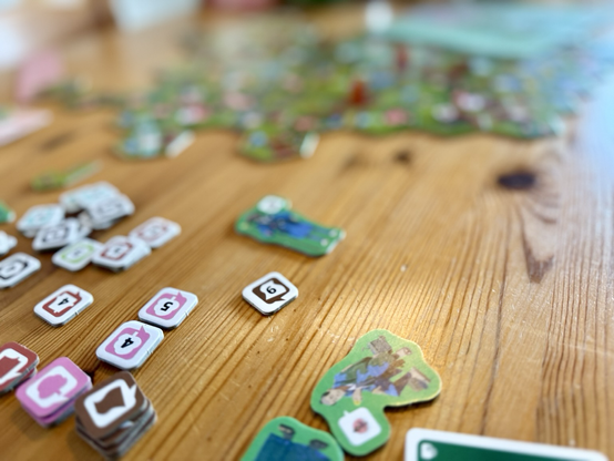 Das Brettspiel Dorfromantik - Sakura auf einem Tisch ausgebreitet.