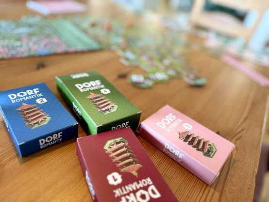 Das Brettspiel Dorfromantik - Sakura auf einem Tisch ausgebreitet.