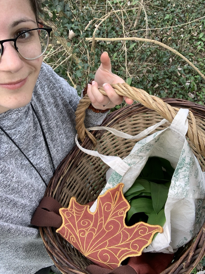 Je tiens mon panier de récolte toute fière, dans un tote bag Les feuilles récoltées, et un sac brodé en forme de feuille
