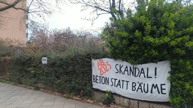 Plakat an einer Kleingartenanlage "Skandal! Beton statt Baume"