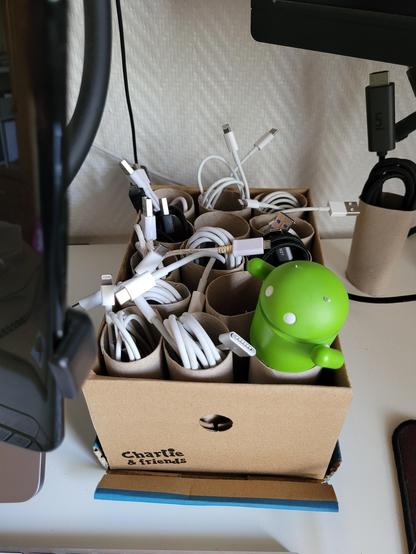 Shoe box with cables in it. Each cable is nicely packed in a paper roll